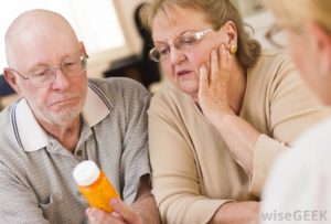 Elderly couple focused on medication.